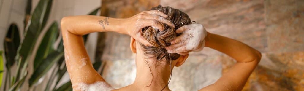 Haarpflege einer Frau mit schaumigen Haaren